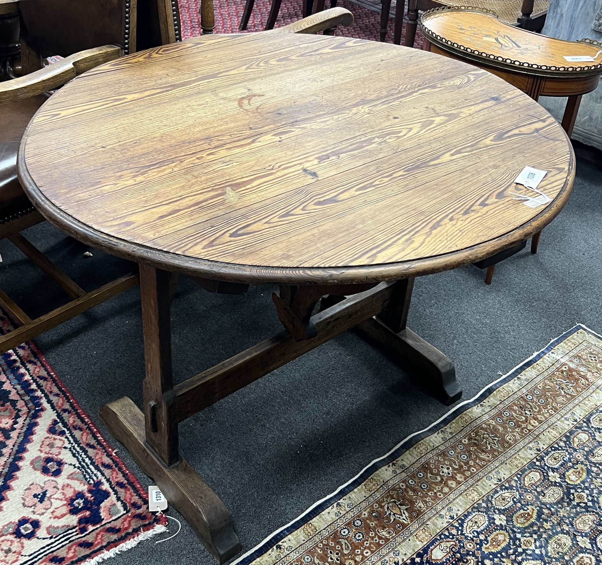 A 19th century French oval oak and pine tilt top folding table, width 90cm, depth 100cm, height 72cm